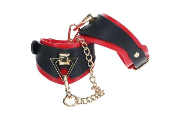 Costrittori BDSM per polsi in PU e metallo regolabili di colore rosso e nero